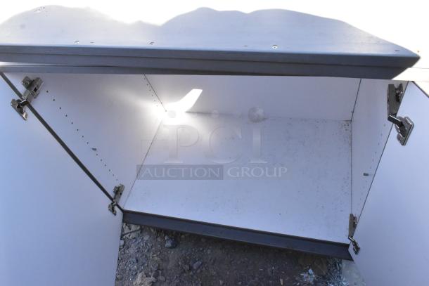 Gray 2 door cart with commercial casters, open interior, visible hinges, minor dirt inside, suitable for storage.