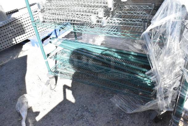 Green 4-tier wire shelving unit with commercial casters, partially wrapped in plastic. Includes contents, buyer dismantles.