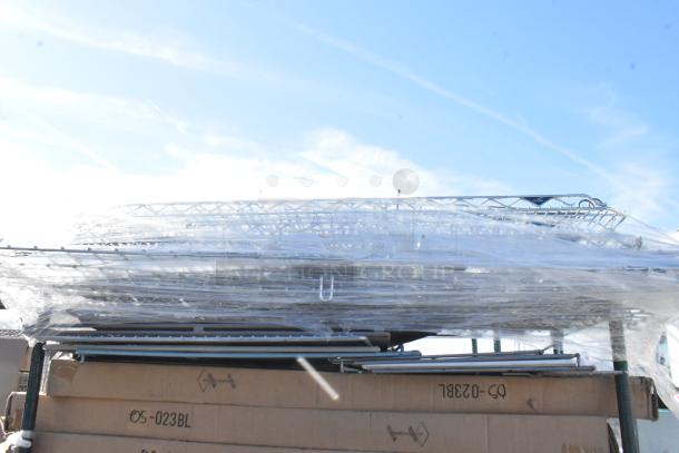 Chrome and green 5-tier wire shelving unit on casters, wrapped for delivery. Buyer dismantles; consider freight costs.