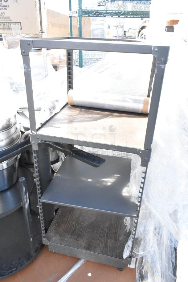 Pallet lot featuring a metal cart with three shelves and a tabletop, showing wear. Includes a plastic wrap roll.