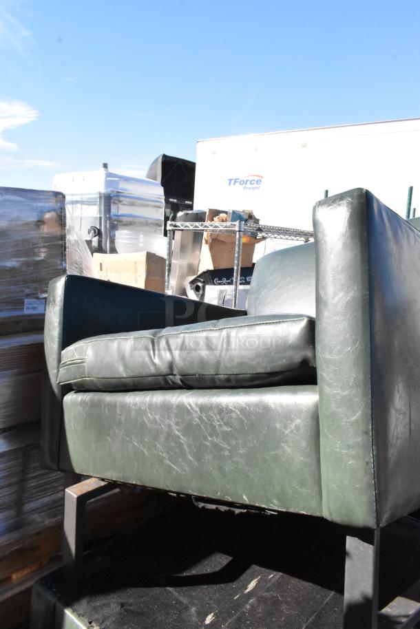 Green leather armchair with cushioned seat, visible wear on the surface, and metal legs. Auction lot includes five chairs.