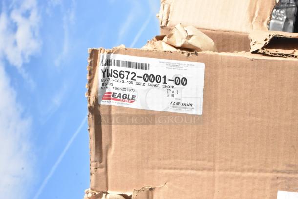Cardboard box with label "Eagle YWS672-0001-00," indicating new scratch-and-dent items. Includes Eagle and metal piece.