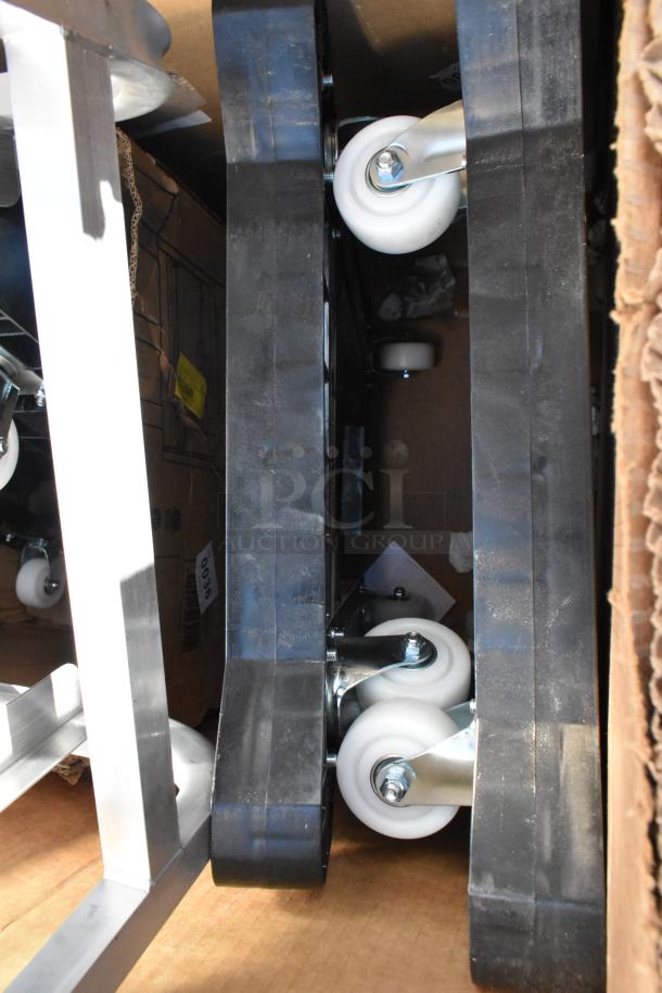 Scratch and dent items with casters, including aluminum table, steel pot rack, and pan rack. Brand new condition.