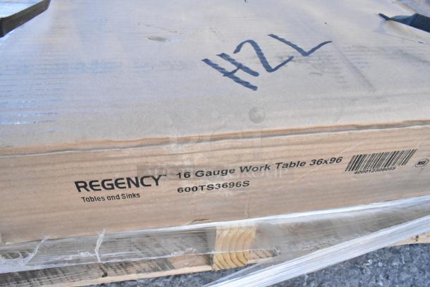 "Regency 600TS3696S 36x96 stainless steel work table in packaging, with visible scratch and dent markings."