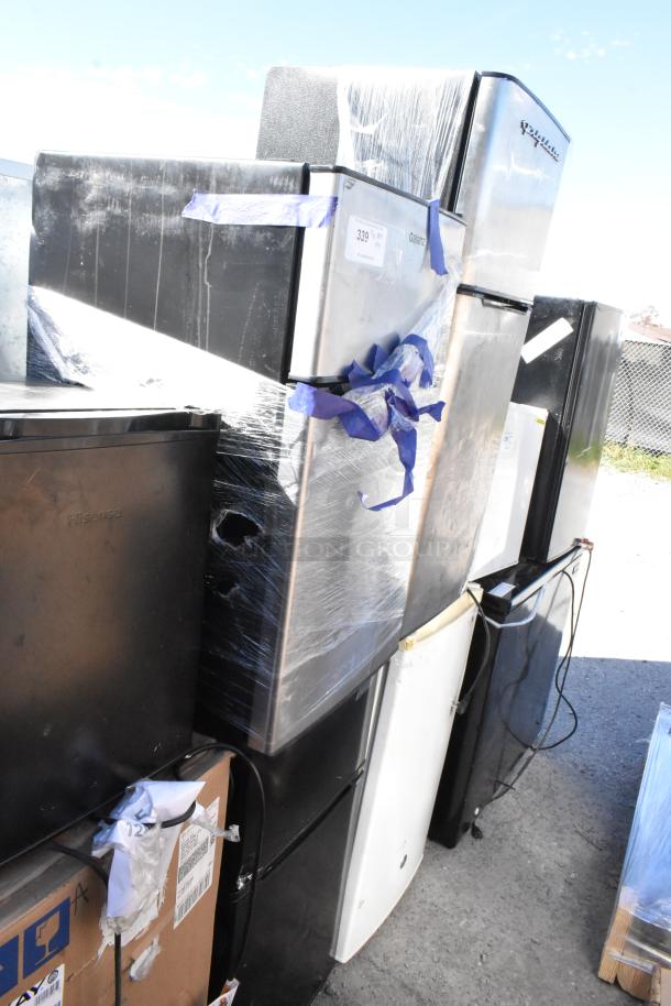 Three mini coolers, including Nostalgia IRF32BK and Haier HSA02WNDWW, 115 volts, 1 phase, stacked and wrapped, showing labels.