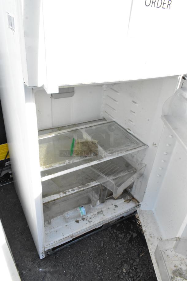 Whirlpool WRT511SZDW00 reach-in cooler with freezer, 115V, shows visible wear, dirt on shelves, some items inside.