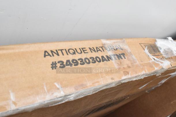 Cardboard box labeled "ANTIQUE NATURAL #3493030ANTNT," indicating contents of new scratch and dent items for auction.