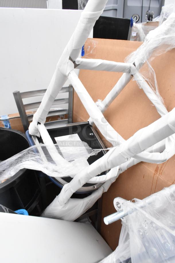 12 new scratch and dent items, including Lancaster table tops, Lavex trash cans, and seating bases, wrapped and stacked.