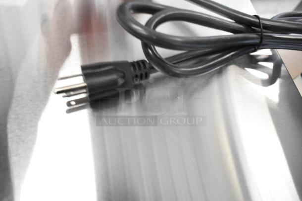 Black power cord resting on stainless steel surface, part of Avantco 177CPO16TSGL countertop pizza oven. Oven missing glass door.