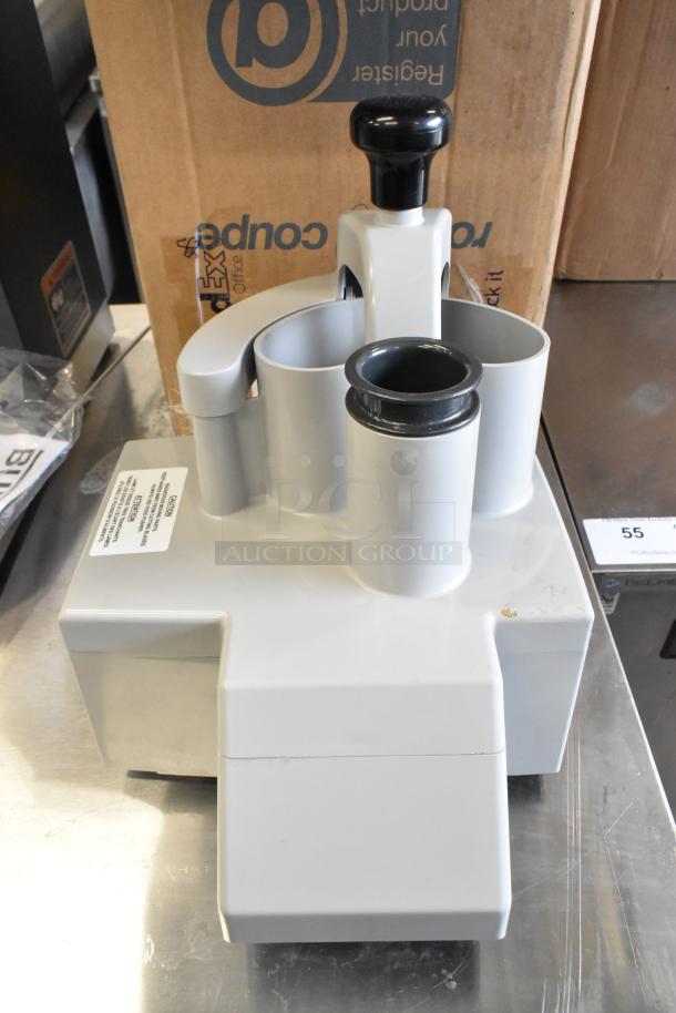 Brand new Robot Coupe 27213 food processor with minor scratches and dents. Visible caution label on the unit.