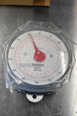 Brand new Taylor high capacity hanging digital scale, model 6083470. Capacity: 70 lb x ½ lb (31 kg x 250 g). Slight scratches and dents, still in packaging.