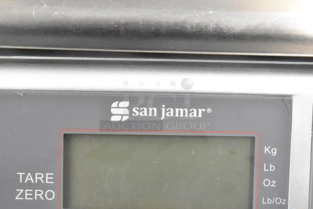 San Jamar digital kitchen scale display, showing brand logo and tare function. New condition with scratch and dent.
