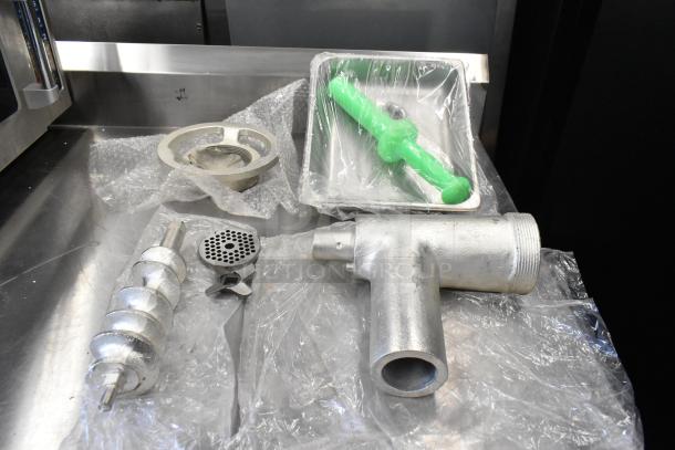 Brand new Assure 190M22HGA meat grinder attachment with stomper for #22 hub, includes auger, grinding plates, and housing.