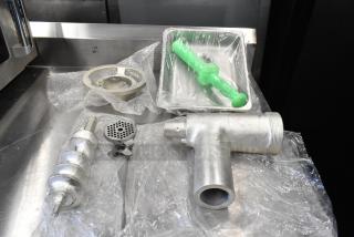 Brand new Assure 190M22HGA meat grinder attachment with stomper for #22 hub, includes auger, grinding plates, and housing.
