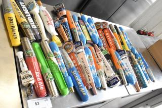 44 assorted beer tap handles featuring brands like Blue Moon, Oktoberfest, and Surly Brewing Co., in excellent condition.