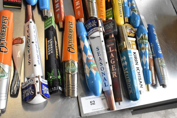44 assorted beer tap handles including Blue Moon, Oktoberfest, Surly Brewing Co.; used condition; visible labels and brand logos.