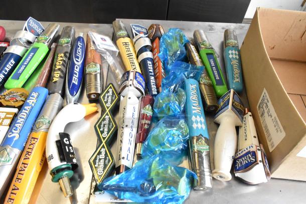 55 assorted beer tap handles including Samuel Adams, various brands and styles, showcasing vibrant designs, in good condition.