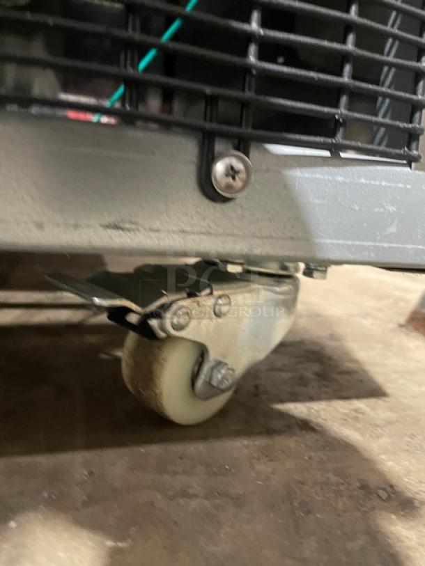 Close-up of caster on Omcan Commercial Refrigerated Bakery Display Case, Model RS-CN-0471-S. Features steel construction.