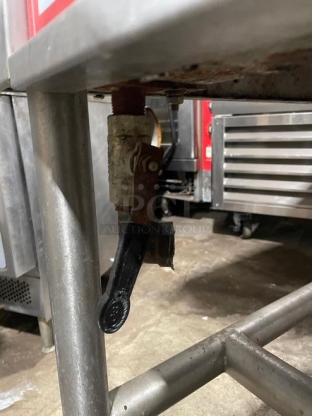 Vulcan commercial stainless steel tilted braising pan, natural gas powered, on sturdy legs, visible valve lever underneath.