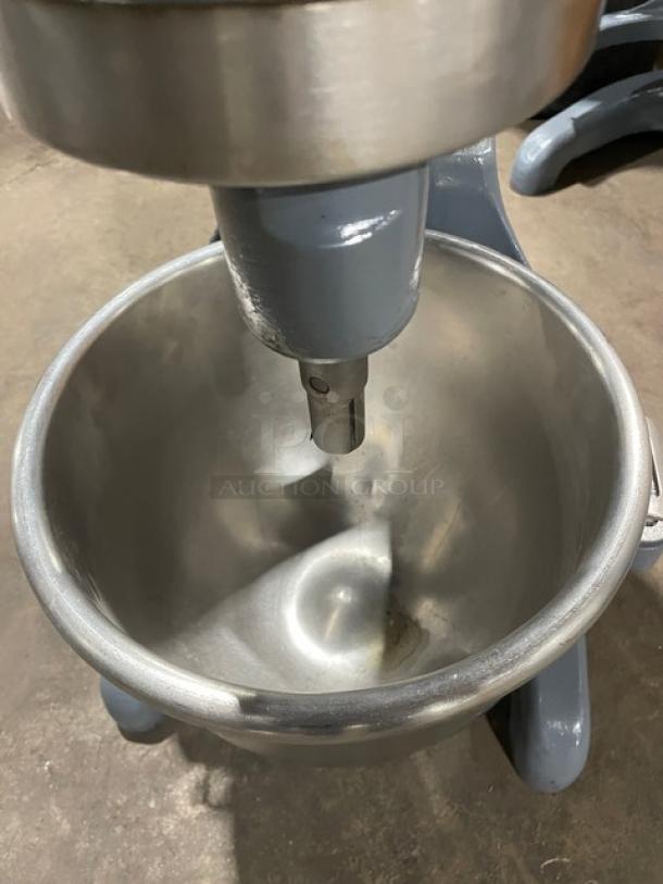 Hobart commercial electric planetary mixer with stainless steel mixing bowl, in good condition, on sturdy legs.