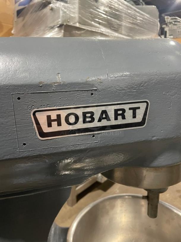 Hobart commercial heavy-duty planetary mixer with mixing bowl, in good condition, features sturdy legs and visible brand logo.