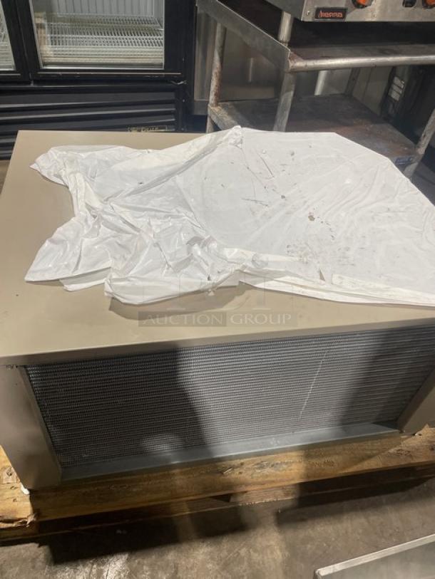 Heatcraft commercial condensing unit, model CZT025M6D, 460V 3-phase. Features mesh grille, in fair condition, partially covered.