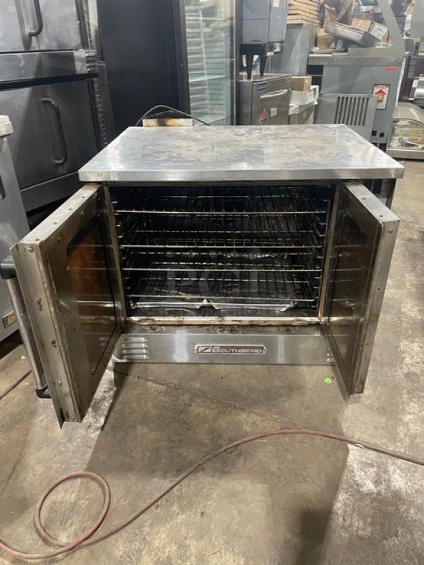 Southbend SL-Series stainless steel natural gas convection oven, single stacked with wired rack, open doors.