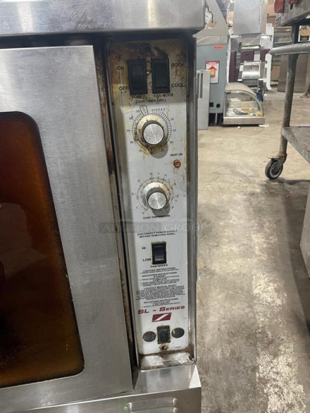 Southbend SL-Series stainless steel natural gas convection oven, equipped with wired rack. Visible wear, labeled controls.