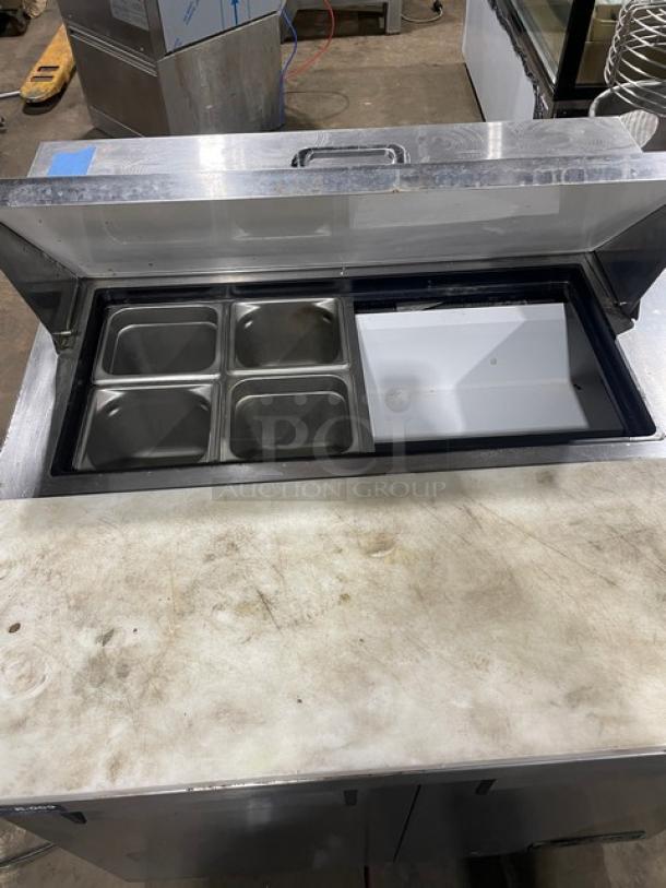 True TSSU-36-08 refrigerated prep table, stainless steel, 2-door, with cutting board, pans, and poly coated rack. On casters.