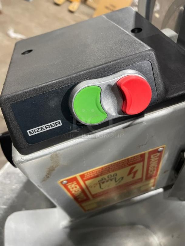 Bizerba commercial electric deli meat slicer, countertop model. Features power buttons. Visible wear; "Danger" label attached.
