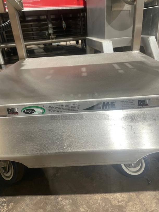 M&E stainless steel commercial equipment cart with slicer-mounting, single undershelf, legs, and casters; branded labels visible.