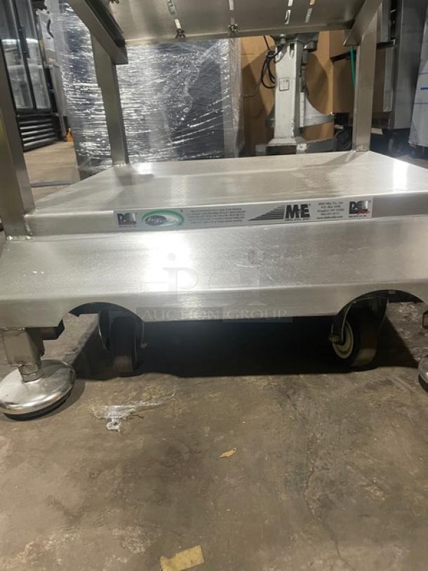 M&E stainless steel deli equipment cart with undershelf, slicer mount, legs, and casters. Features branding labels.