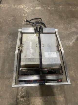 Commercial stainless steel electric countertop dual panini press grill with two heated plates. Used condition, on legs.