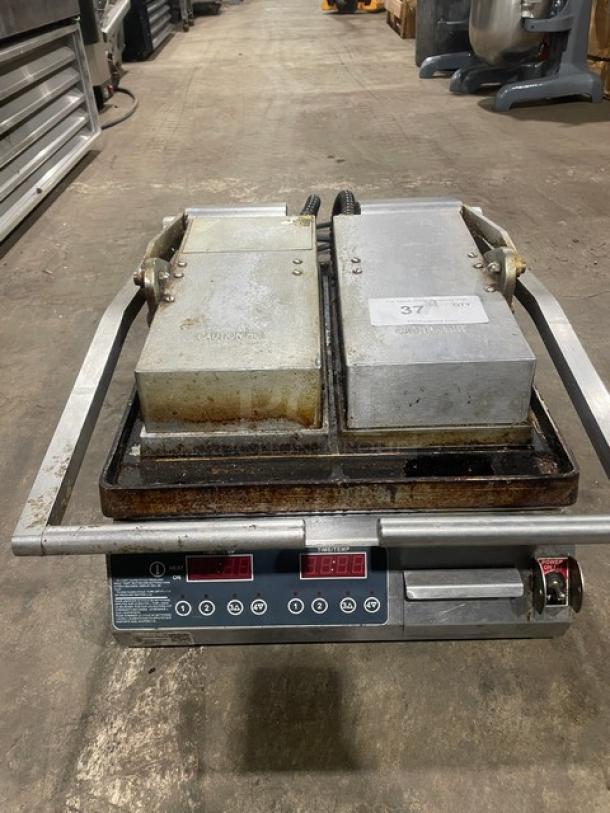 Commercial stainless steel electric dual panini press grill with digital controls, moderate wear, on legs. Suitable for countertop use.