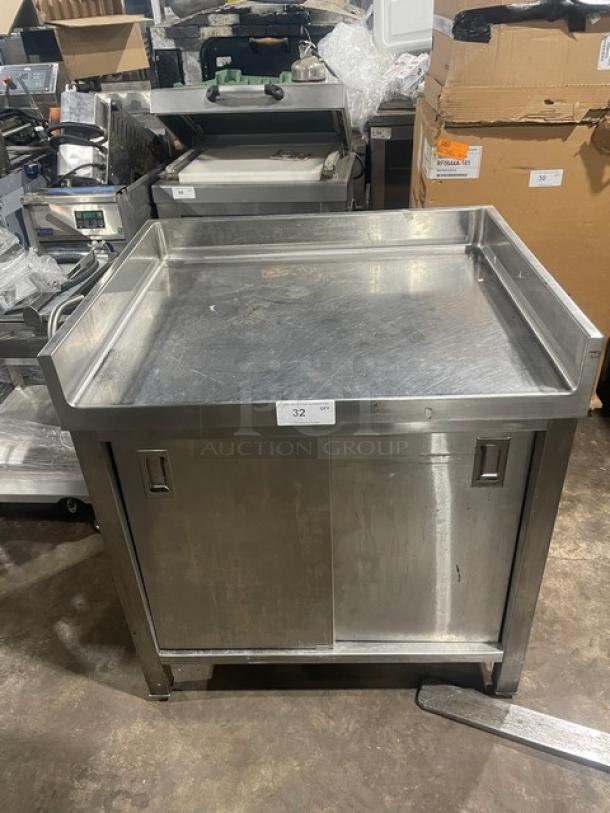 Commercial stainless steel worktop table with enclosed cabinet base, upturned back and side splash, on legs, item 32 tag.