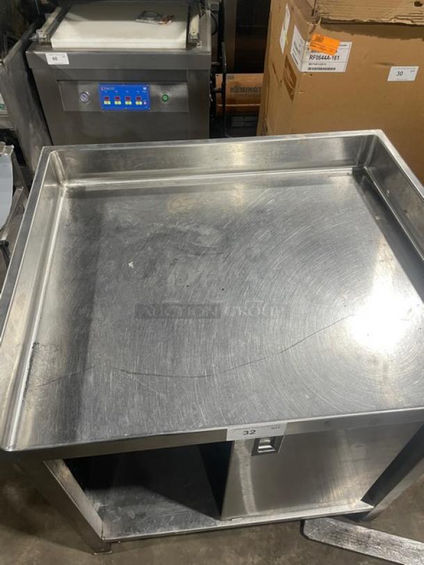 Commercial stainless steel worktop table with enclosed cabinet base, upturned back and side splash, and legs; used condition.