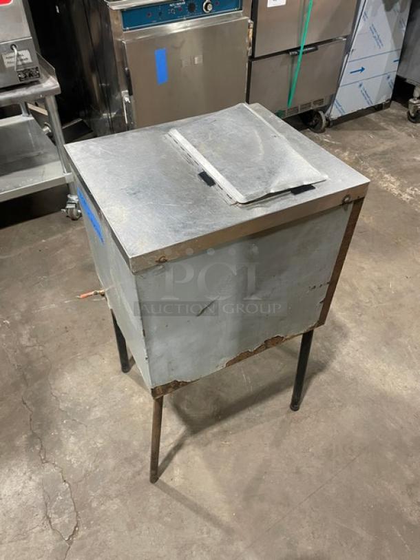 Commercial stainless steel ice crushing machine on legs, wooden style finish, shows wear, ideal for high-volume use.