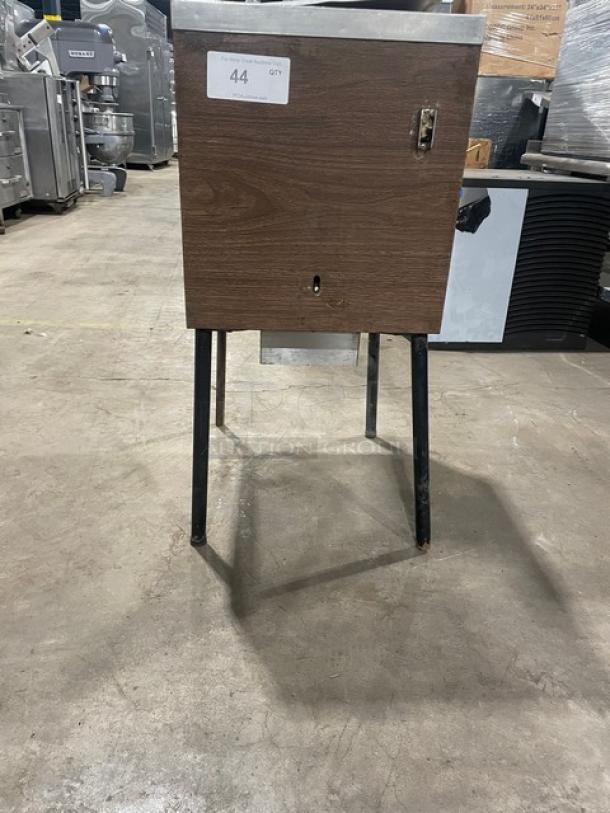 Commercial stainless steel ice crushing machine with wooden style finish, mounted on legs. Appears in used condition.