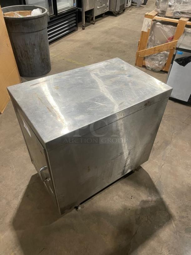 Commercial stainless steel enclosed cabinet worktop on casters; durable, used condition with visible surface marks.