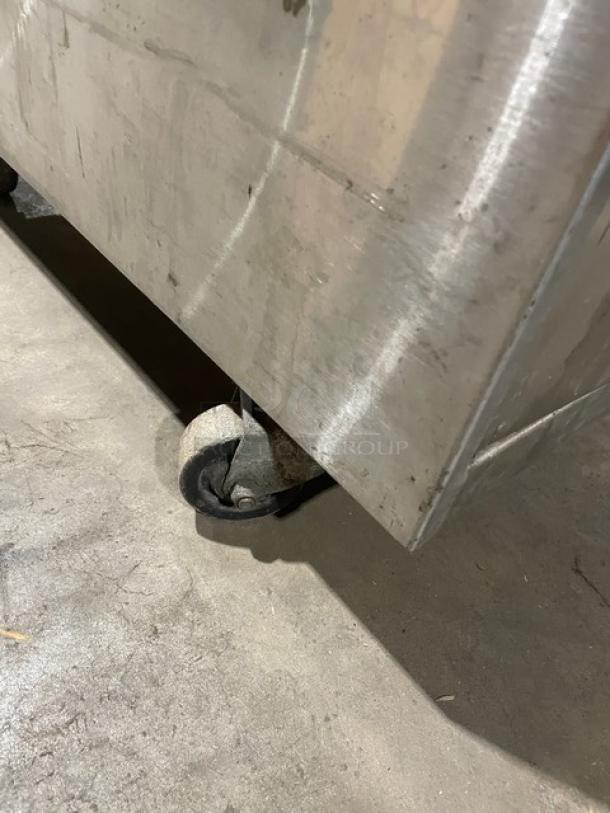 Stainless steel cabinet worktop base on casters, commercial-grade, dry enclosed style, showing minor surface wear.
