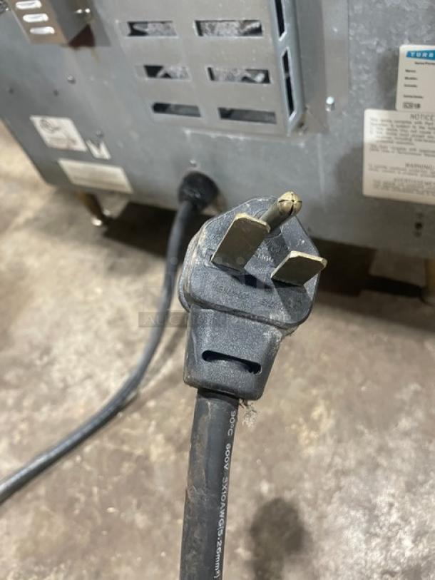 TurboChef NGC commercial oven back view showing power cord and plug. Includes visible model and serial number tags.