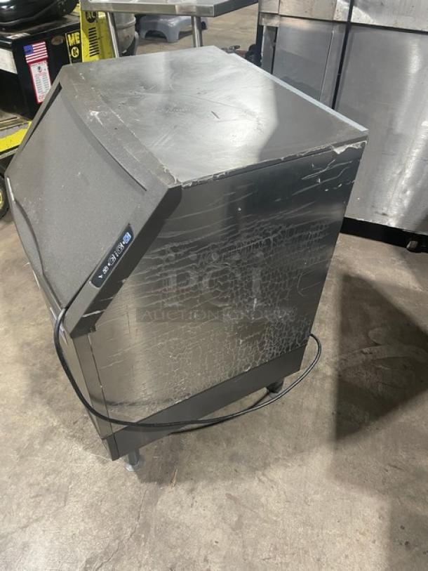 Manitowoc stainless steel undercounter ice maker with bin, electric-powered, on legs, visible wear, SN: 310620659.