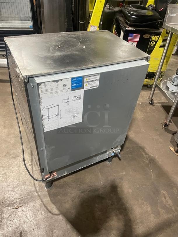 Manitowoc stainless steel undercounter ice machine, model SN:310620659, 115V 1 phase, on legs, visible wear, instructions on side.