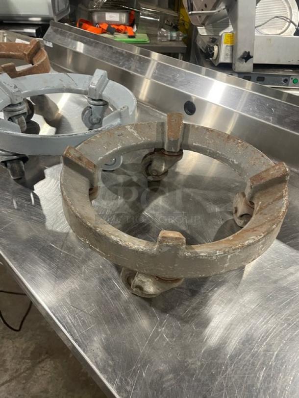 Heavy duty round trash can dolly with casters. Metal construction, three visible in image. Used condition, signs of wear.