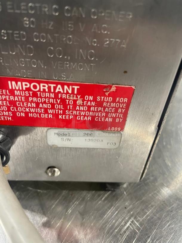 Edlund Model 266 electric can opener, stainless steel, serial 139203, with operational instructions label, on legs.