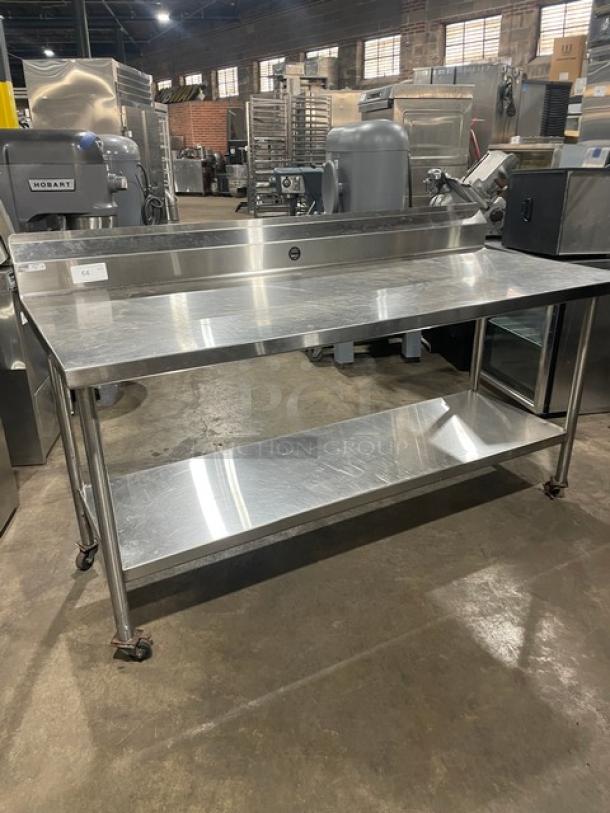 Commercial stainless steel prep table with undershelf, up-turned backsplash, and casters in good condition.