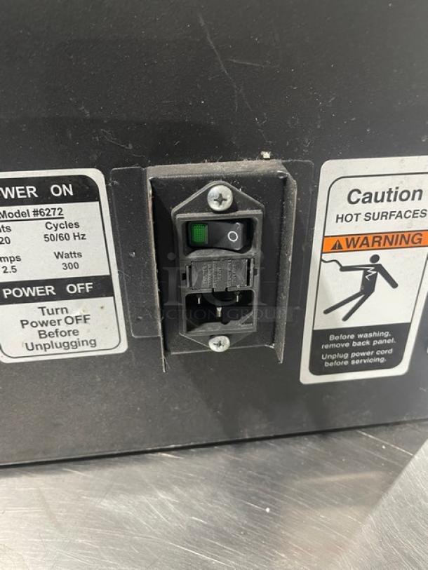 Forbes Ultra Series model 6272 black 3-tier insulated food carrier with stainless steel interior, 120V. Labels show power specs and safety warnings.