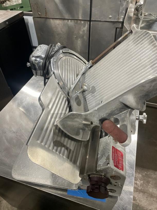 Globe Model 660 commercial deli meat slicer on legs. Features include adjustable blade and slicing table. Serial number 674425.