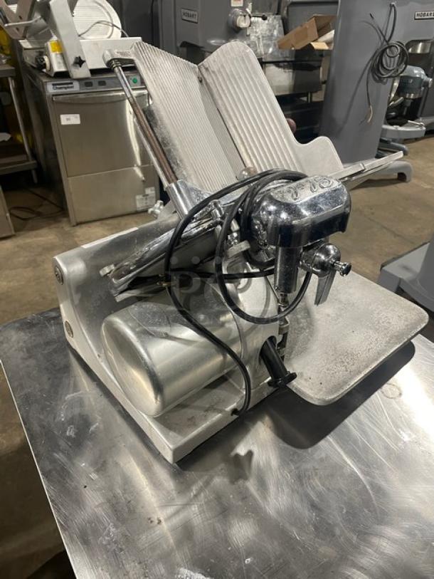 Globe Model 660 electric deli meat slicer on legs. Visible wear, metal finish, serial number 674425.