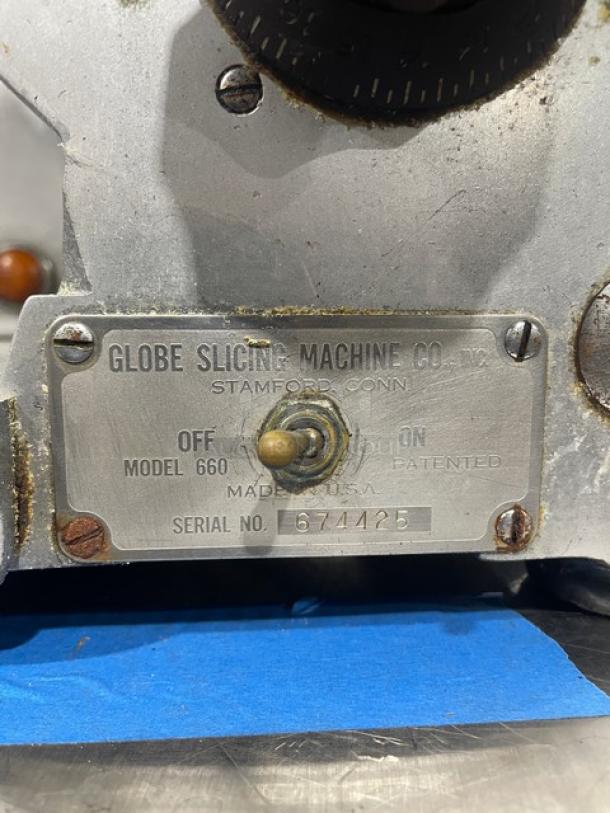 Globe 660 electric deli slicer, serial 674425, with label showing model and serial number, on metal legs.